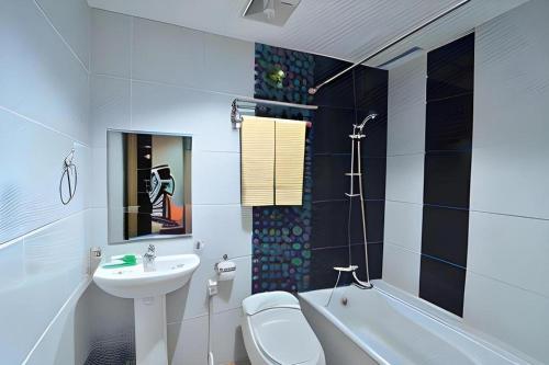 a bathroom with a sink and a toilet and a bath tub at The Aroma's of Bali Hotel & Residence in Legian