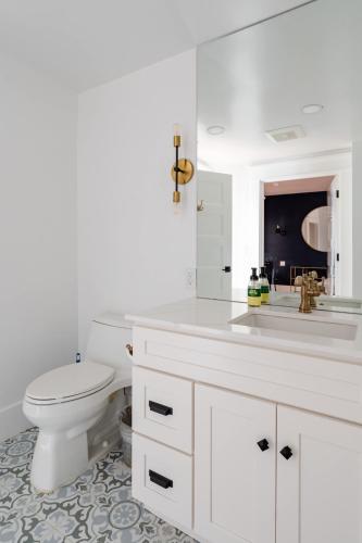 a white bathroom with a toilet and a sink at Stay Portland - Sophisticated 2BR - Prime NW 23rd Location in Portland
