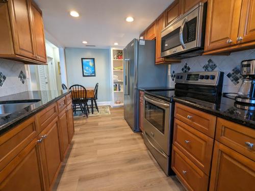 a kitchen with wooden cabinets and stainless steel appliances at Beachfront Condo, Ocean Views, Near Patrick SFB in Satellite Beach