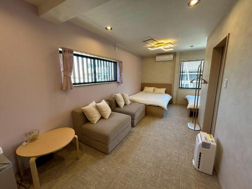 a living room with a couch and a bed at SANDBoX in Oshima