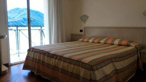 a bedroom with a bed and a large window at Hotel Elena in Recco