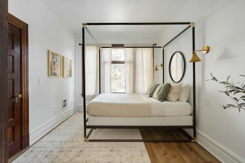 a bedroom with a canopy bed with a window at Stay Portland - The Étoile Suite - Nob Architecture & Boutiques in Portland