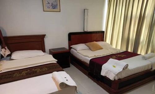 a bedroom with two beds and a window at J Hotel Bukit Bintang in Kuala Lumpur