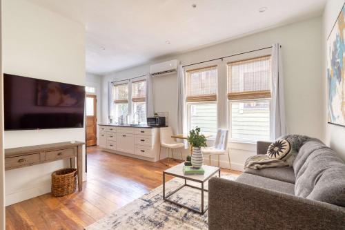 a living room with a couch and a tv at Stay Portland - The Etourdissante Suite - Forest Park & Local Eats in Portland