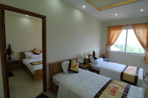 a hotel room with two beds and a mirror at Lam Ha Resort in Phu Quoc