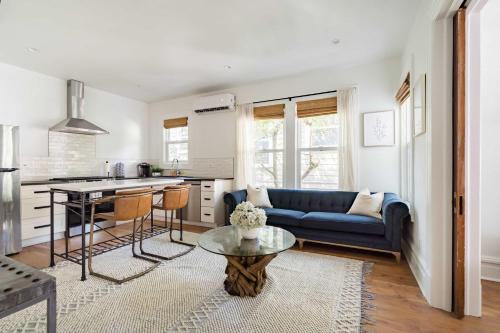a living room with a blue couch and a table at Stay Portland - The Câlin Suite - Posh Local Boutiques & Eateries in Portland
