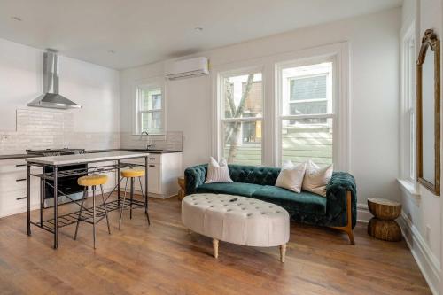 a living room with a green couch and a kitchen at Stay Portland - 1BR - Walk to Coffee, Brews & NW 23rd Shops in Portland