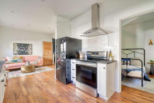 a kitchen with a stainless steel stove and a living room at Stay Portland - The Trésor Suite- Cold Brew & Craft Beers in Portland