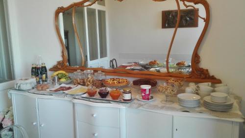 a buffet of food on a dresser in front of a mirror at AL 32 B&B in Massa Marittima