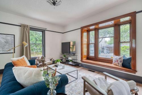 ein Wohnzimmer mit einem blauen Sofa und Fenstern in der Unterkunft Stay Portland - Luxury Living on NW 23rd Ave, Walk Score 99 in Portland