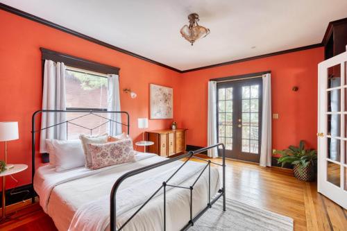 1 dormitorio con paredes de color naranja y 1 cama en Alphabet District Gem - AC - Patio - Fast WiFi, en Portland