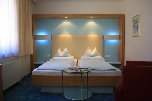 una camera d'albergo con due letti e un tavolo di Dom Hotel a Linz