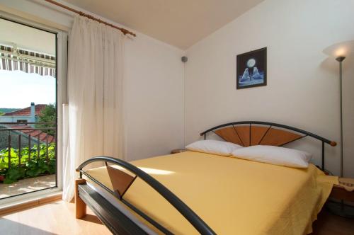 een slaapkamer met een bed en een groot raam bij Holiday Home Ruda in Vinišće