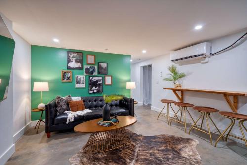 a living room with a black couch and a green wall at Stay Portland - 1910 Historic Jessie Morehead House - 98 WalkScore in Portland