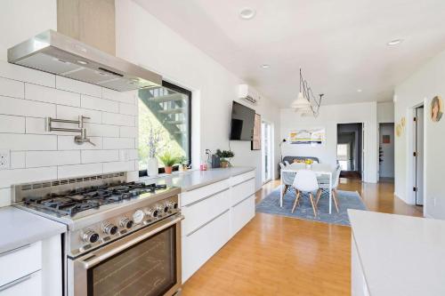 a white kitchen with a stove and a dining room at Luxurious Portland 3BR in the Pearl District in Portland