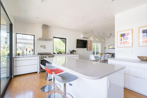 a kitchen with white cabinets and a bar with stools at Luxurious Portland 3BR in the Pearl District in Portland