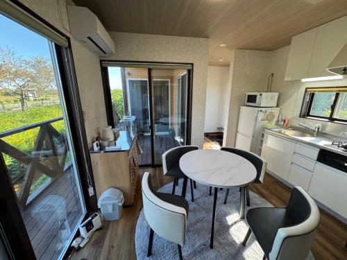 eine Küche und ein Esszimmer mit Tisch und Stühlen in der Unterkunft レイクウエスト4-711 in Wada