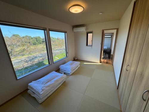 2 Betten in einem Zimmer mit 2 großen Fenstern in der Unterkunft レイクウエスト4-711 in Wada