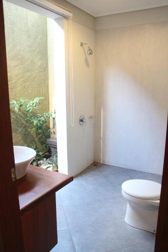 a bathroom with a toilet and a sink at Betutu Bali Villas in Ubud