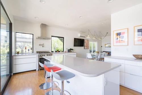 a kitchen with a large white counter and stools at Stay Portland - Unique 8 BR Private Home in Pearl District in Portland