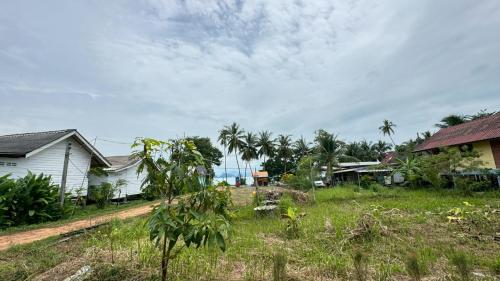 a house and a yard with houses and the ocean at Cheriya bungalow Kohyaonoi in Ban Laem Sai