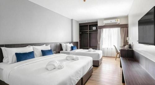 a hotel room with two beds with blue pillows at XOTEL in Ban Non Muang