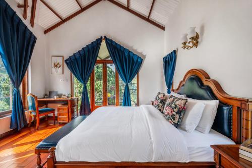 una camera da letto con un grande letto con tende blu di The Winterfel a Yedapalli