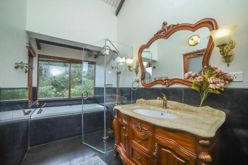 un bagno con un lavandino, una vasca e uno specchio di The Winterfel a Yedapalli