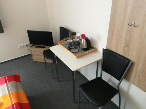 a room with a desk with chairs and a table with cups and flowers at Villa Marcus - rodinný relax 200 m od Penzionu Kometa, u jezera s grilem a sdílenou kuchyní in Pasohlávky
