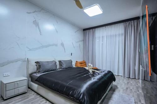 a bedroom with a large bed and a white wall at DreamHouse in Ban Bang Khu