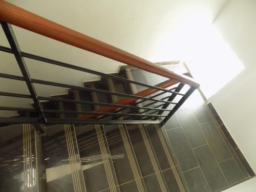 a stairwell with a metal railing and a staircase at Fort Fun City Hotel Fort Portal in Fort Portal
