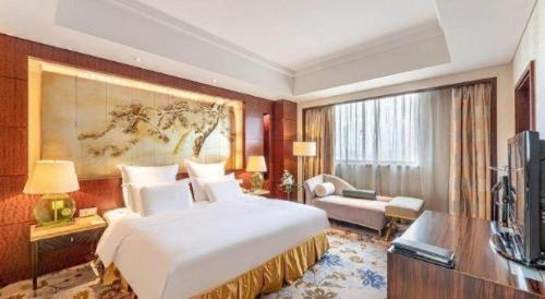 a hotel room with a large bed and a television at Kunshan Newport Hotel in Kunshan