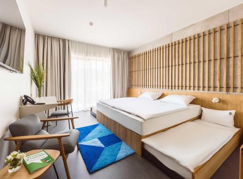 a hotel room with two beds and a desk at Hotel Well Family in Tuheljske Toplice