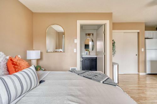 a bedroom with a large bed with orange pillows at Stay Portland - John's Landing Haven - Studio Near OHSU in Marquam Hill