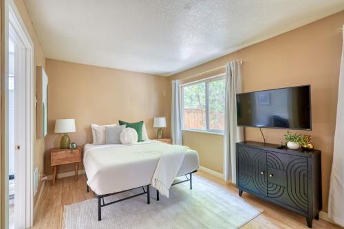 a bedroom with a bed and a flat screen tv at Stay Portland - Peaceful Johns Landing Studio - Near OHSU in Marquam Hill