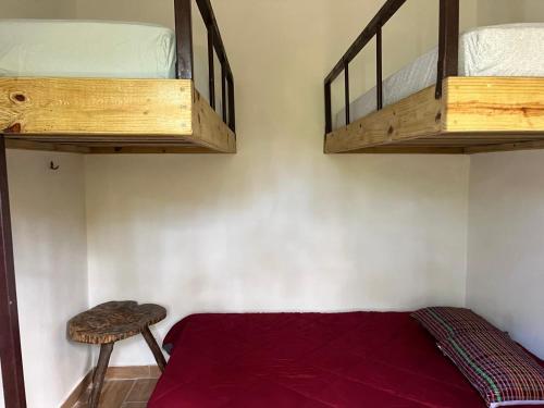 a bedroom with two bunk beds and a stool at La Casa del rio in Los Altos de Cerro Azul