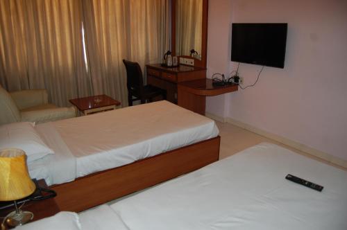 a hotel room with two beds and a flat screen tv at Devi Towerrs 5 Roads in Salem