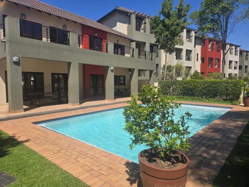 a swimming pool in front of a building at Stylish Bachelor Pad in the Heart of Fourways in Sandton