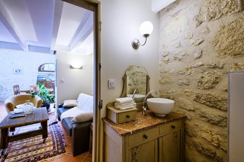 a bathroom with a sink and a living room at La Grange d'Oustaud in Vérac