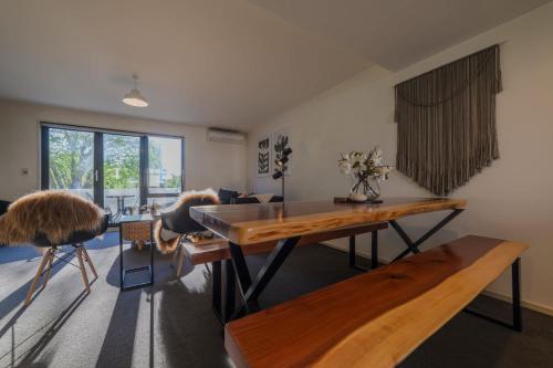 a living room with a wooden table and chairs at Elegant 3-Storey Townhouse with Garage Parking by Latimer Sq in Christchurch