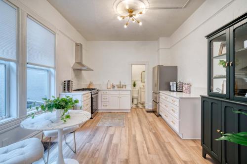 a large kitchen with white cabinets and a table at Stay Portland - Historic Queen Anne Vernacular - 95 WalkScore in Portland