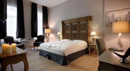 a hotel room with a bed and a desk and chairs at Locanda In Borgo Garnì & Wellness in Borgo