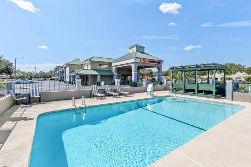 a swimming pool with chairs and a gazebo at Econo Lodge Goose Creek - Charleston North in Goose Creek