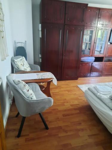 a room with two beds and a table and a chair at DÉNY APARTMAN in Sfântu-Gheorghe