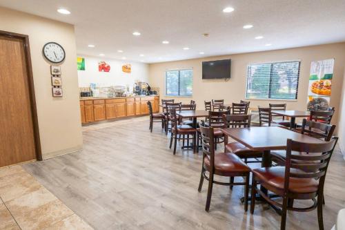 a restaurant with tables and chairs and a clock at Quality Inn & Suites Sun Prairie Madison East in Sun Prairie