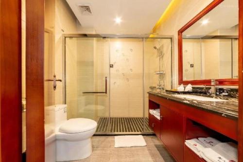 a bathroom with a shower and a toilet and a sink at Royal Bay Hotel in Towmoon