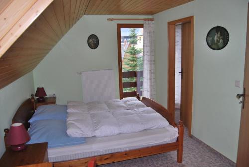 クアオルト・オーバーヴィーゼンタールにあるFerienhaus Keilbergblickの白いシーツと窓のあるベッドのある寝室
