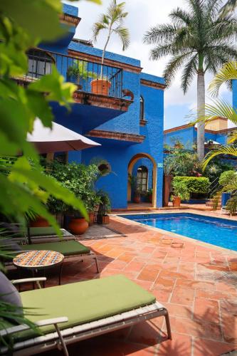 a blue building with a swimming pool and palm trees at La Villa del Ensueno Boutique Hotel in Guadalajara