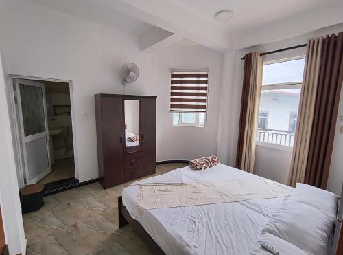 a bedroom with a large bed and a large window at KBK Furnished Apartments, Digana in Gomagoda