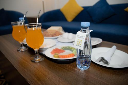 una mesa con platos de comida y una botella de agua en فندق اهلا Hola Hotel, en Al Jubail